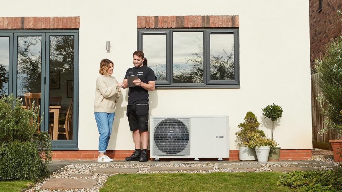 Abode installer discussing a heat pump installation with a homeowner